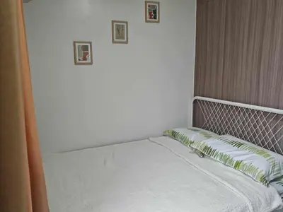 a bed in a bedroom with two pictures on the wall at Zeki's Place - Shore 2 Residences MOA in Manila