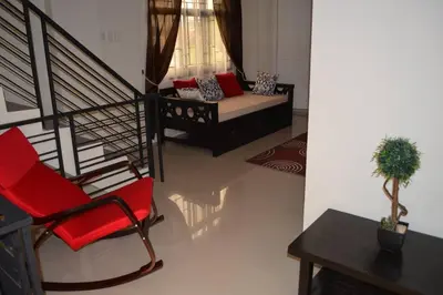 a living room with a red chair and a couch at Home in Pasig in Manila