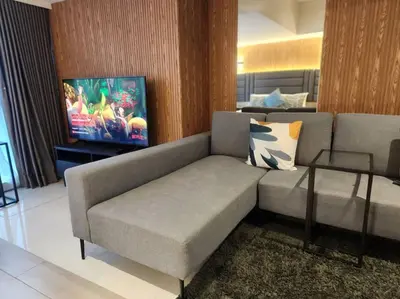a living room with a couch and a tv at BGC Cosy Hotel Vibe Uptown Parksuites Studio in Manila