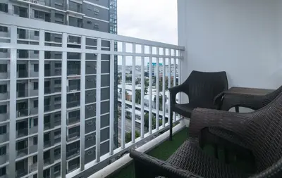 two chairs on a balcony with a view of a city at Lascianos SMDC Shore Residences by RedDoorz in Manila