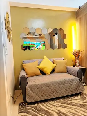 a couch in a living room with a mirror at Fame Residence Tower 1 Cozy Hotel Style 1 Bedroom with Balcony pool View in Manila
