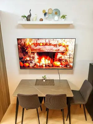 a living room with a fireplace painting on the wall at Fame Residence Tower 1 Cozy Hotel Style 1 Bedroom with Balcony pool View in Manila