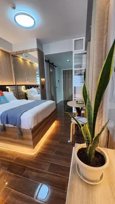 a bedroom with a bed and a potted plant on a table at Air residence Fantasy Sophisticated Chic Family living 300 Mbps Fast in Manila