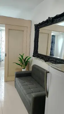 a living room with a couch and a mirror at Eriel condotel in Manila