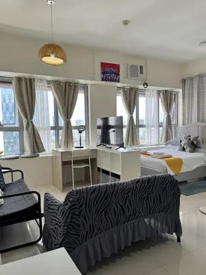 a bedroom with a bed and a desk in a room at Perfect accommodation for you in Levels Burbank in Manila