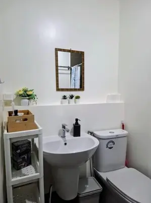 a bathroom with a sink and a toilet and a mirror at Perfect accommodation for you in Levels Burbank in Manila