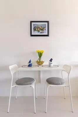 a white table with two chairs and a vase of flowers at Perfect accommodation for you in Levels Burbank in Manila
