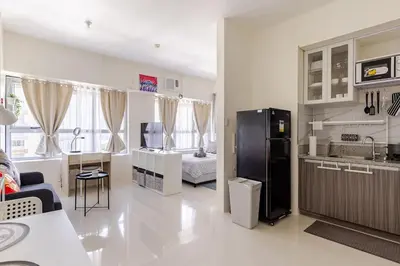 a kitchen and living room with a black refrigerator at Perfect accommodation for you in Levels Burbank in Manila