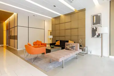 a living room with orange chairs and a couch at Perfect accommodation for you in Levels Burbank in Manila
