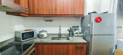 a small kitchen with a sink and a refrigerator at Elite Homestays Family-Friendly Condo Near Malls with Pool & Gym in Manila
