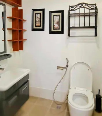 a white bathroom with a toilet and a sink at Elite Homestays Family-Friendly Condo Near Malls with Pool & Gym in Manila