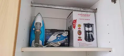 a shelf with a surfboard and a box on it at Elite Homestays Family-Friendly Condo Near Malls with Pool & Gym in Manila
