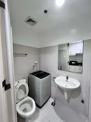 a bathroom with a toilet and a sink at Oasis MOA- Sea Residences in Manila