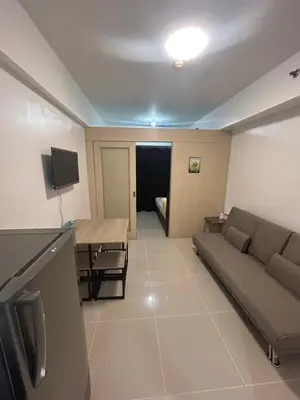 a living room with a couch and a table at Oasis MOA- Sea Residences in Manila