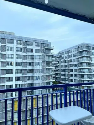 a balcony with a table and some buildings at Oasis MOA- Sea Residences in Manila