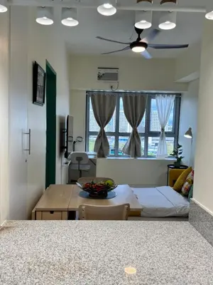 a living room with a bed and a table and windows at Levels Executive Residences in Manila