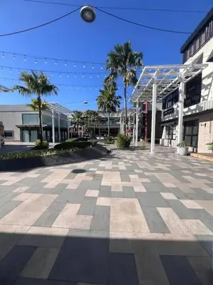 an empty street with palm trees and a building at Levels Executive Residences in Manila