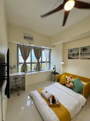 a bedroom with a large bed and a desk in it at Levels Executive Residences in Manila