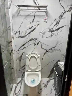 a bathroom with a white toilet and a marble wall at Luxury Style Living-Netflix Ready in Manila