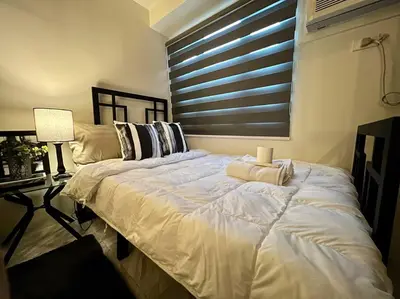 a large white bed in a room with a window at Luxury Style Living-Netflix Ready in Manila