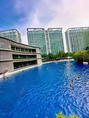 a large swimming pool in front of tall buildings at 2 Bedroom Summer Themed Unit at Azure in Manila