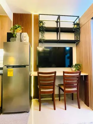a kitchen with a refrigerator and a table with two chairs at Alonas Residences in Manila
