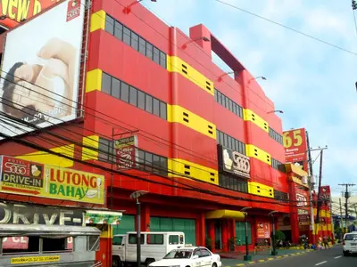 a red and yellow building with cars parked in front of it at Hotel Sogo - EDSA, Pasay Harrison in Manila