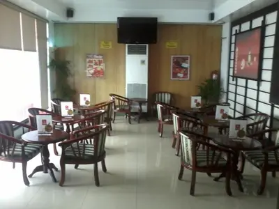 a dining room with tables and chairs and a television at Hotel Sogo - EDSA, Pasay Harrison in Manila