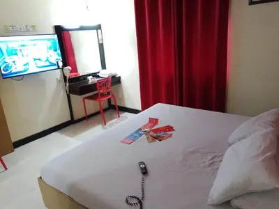 a bedroom with a bed with a remote control on it at Hotel Sogo - EDSA, Pasay Harrison in Manila