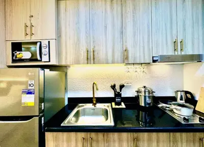 a kitchen with a sink and a refrigerator at Hotel-Like Staycation2 MOA Pasay in Manila
