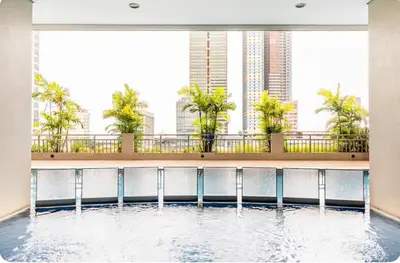 a swimming pool in the middle of a building with palm trees at 8 Adriatico Homestay - S in Manila