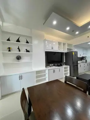 a kitchen with white cabinets and a table and a black refrigerator at YAM's WANDERLUST in Manila