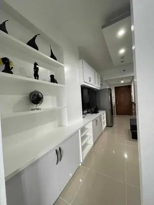 a white kitchen with white shelves and a refrigerator at YAM's WANDERLUST in Manila