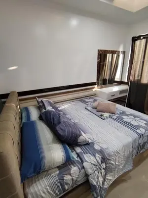 a bed in a living room with a couch at YAM's WANDERLUST in Manila