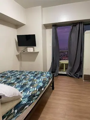 a bedroom with a bed and a window with a view at Tivoli Garden Residences, 1 Bedroom unit with sunset view in Manila
