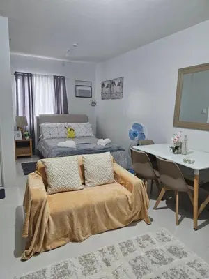 a living room with a bed and a table and a dining room at 5F J Phase1 Sevilla in Manila