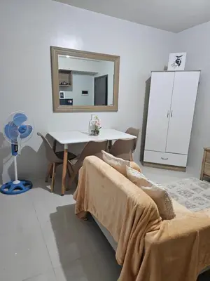 a bedroom with a bed and a desk and a mirror at 5F J Phase1 Sevilla in Manila
