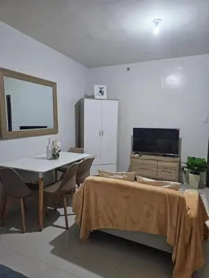 a living room with a table and a tv at 5F J Phase1 Sevilla in Manila