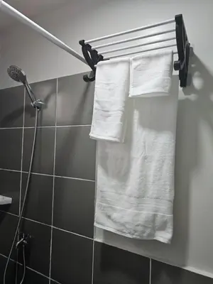 a bathroom with white towels on a towel rack at 5F J Phase1 Sevilla in Manila