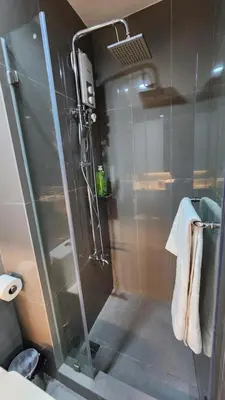a shower with a glass door in a bathroom at Makati Air Luxury Package - Laugh Sleep Brunch Surf 300 mbps Fast in Manila