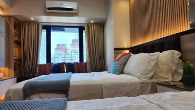 a bedroom with a large bed and a large window at Makati Air Luxury Package - Laugh Sleep Brunch Surf 300 mbps Fast in Manila