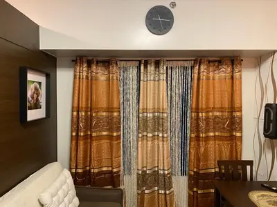 a room with a couch and a clock on the wall at Makati Air Luxury Package - Laugh Sleep Brunch Surf 300 mbps Fast in Manila