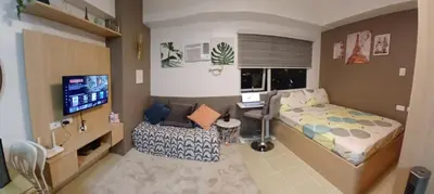 a small bedroom with a bed and a desk at Covent Garden South Residences in Manila