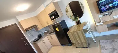 a kitchen with a black refrigerator and a mirror at Covent Garden South Residences in Manila