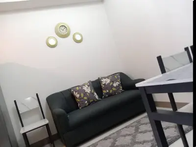 a living room with a black couch and a table at Luxury Bayview Condo MOA & PICC Free WiFi in Manila
