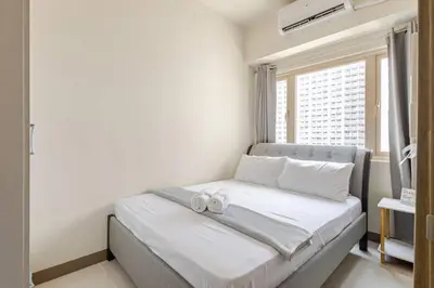 a bedroom with a bed with two towels on it at Luxury Bayview Condo MOA & PICC Free WiFi in Manila