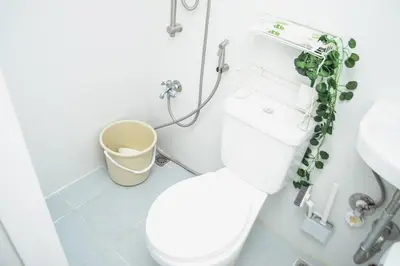 a bathroom with a toilet and a sink at Metro Stay - Prime Spot Near Malls & Major Cities in Manila