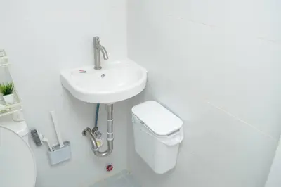 a white bathroom with a sink and a toilet at Metro Stay - Prime Spot Near Malls & Major Cities in Manila
