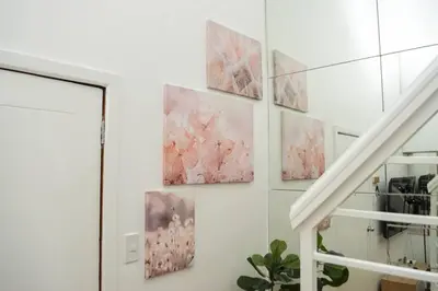 a group of paintings hanging on a wall at Metro Stay - Prime Spot Near Malls & Major Cities in Manila