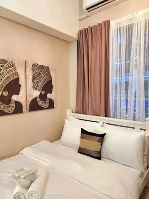a bedroom with a bed with two pictures on the wall at Payapa Staycation by DC in Manila